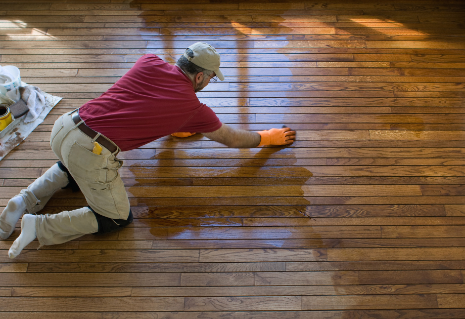 man on floor staining hardwood floor